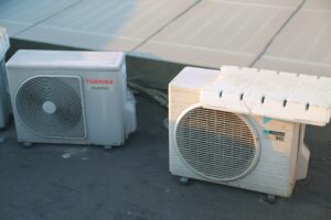 A homeowner changing an HVAC system air filter in a residential utility room.